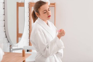 Banyoda jileti olan üzgün genç bir kadın.