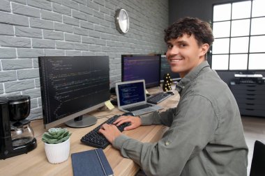 Ofiste bilgisayarla çalışan erkek programcı