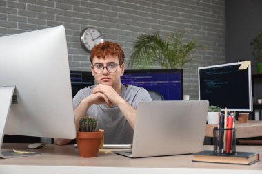 Ofiste bilgisayarla çalışan erkek programcı