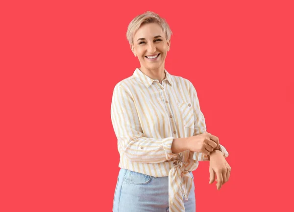Mature Woman Rolling Her Sleeve Red Background — Stock Photo, Image