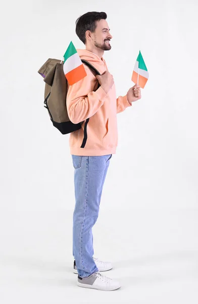 Handsome man with flag of Italy and backpack on white background