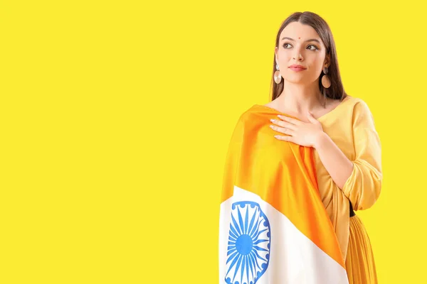 Young woman with Indian flag on yellow background