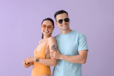 Leylak arka planda güneş gözlüklü genç çift