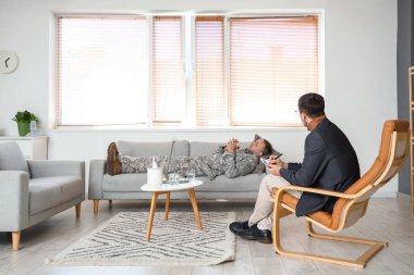 Erkek psikolog ofiste olgun bir askerle çalışıyor.