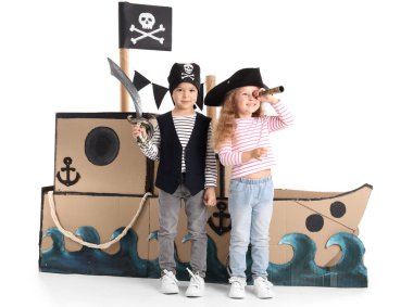 Beyaz arka planda oyuncaklarla oynayan sevimli küçük korsanlar.