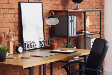 Ofisinde dizüstü bilgisayarı olan modern işyeri