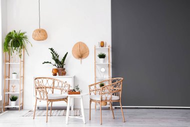 Koltukları, masası ve çiçekleri olan oturma odasının içinde.