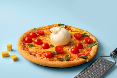 Mavi arka planda Burrata peynirli lezzetli pizza.