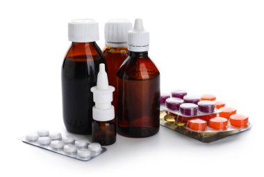Beyaz arka planda farklı haplar ve ilaç şişeleri