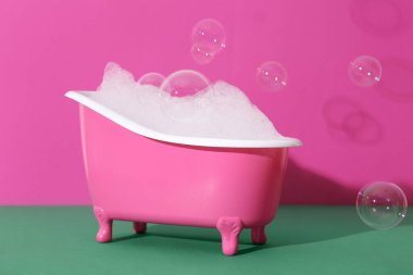 Sabun köpüklü küçük küvet ve renk arkaplanda kabarcıklar