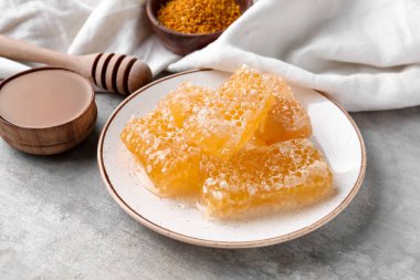 Gri arka planda tatlı bal petekleri olan tabak