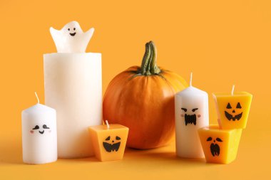 Sarı arka planda Cadılar Bayramı için mum ve balkabağı.