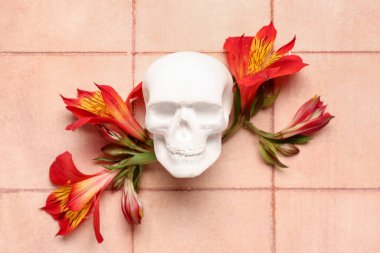 Pembe arka planda güzel zambak çiçekleri olan insan kafatası