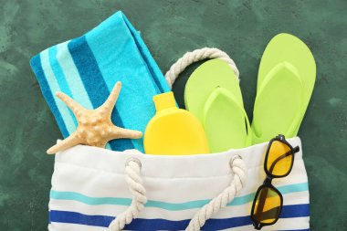 Bir çift yeşil parmak arası terlik çanta ve kumsal aksesuarları grunge yeşil arka planda