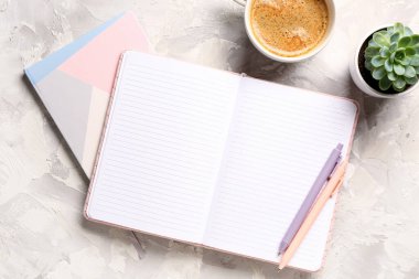 Not defterleri ve arka planda bir fincan lezzetli kahve.