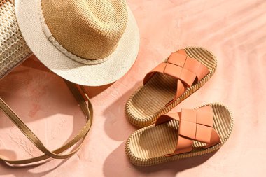 Grunge pembe arka planında plaj aksesuarları olan şık bayan terlikleri.