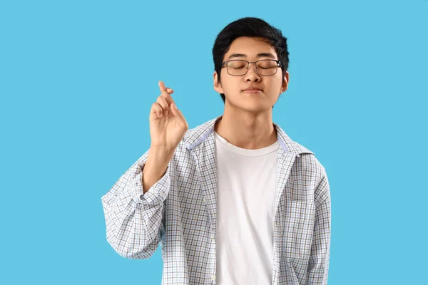 Joven Asiático Hombre Cruzar Dedos Azul Fondo — Foto de Stock