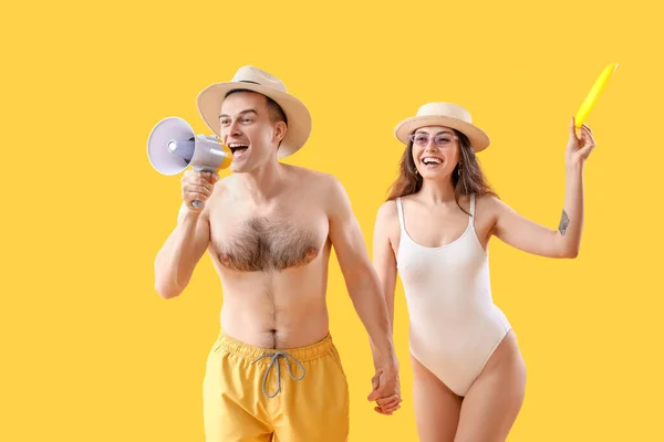 Junges Paar Mit Frisbee Scheibe Und Megafon Auf Gelbem Hintergrund — Stockfoto