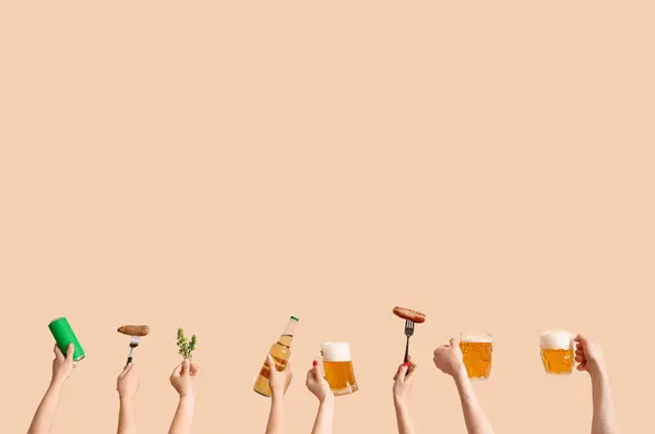 People with beer and sausages on beige background
