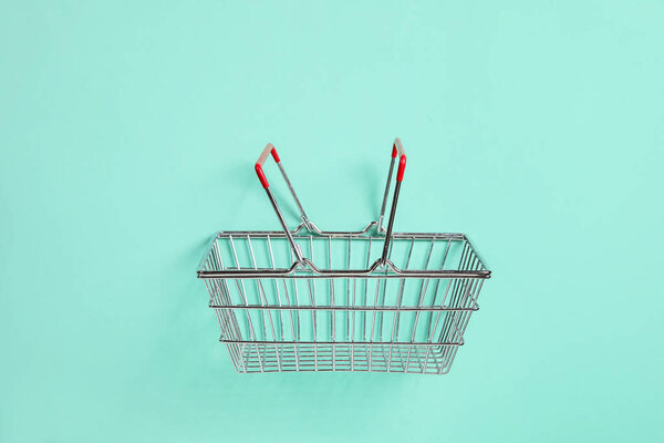 Shopping basket on turquoise background