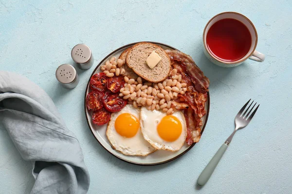 Lezzetli Ngiliz Kahvaltı Tabağı Mavi Arka Planda Bir Fincan Çay — Stok fotoğraf