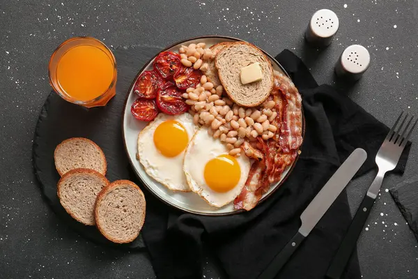 Πιάτο Νόστιμο Αγγλικό Πρωινό Και Ένα Ποτήρι Χυμό Μαύρο Φόντο — Φωτογραφία Αρχείου