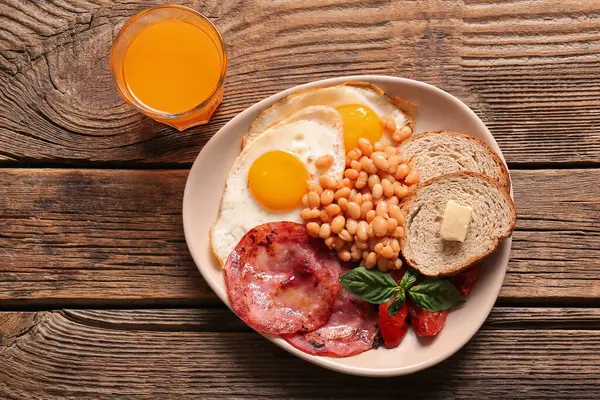Πιάτο Νόστιμο Αγγλικό Πρωινό Και Ένα Ποτήρι Χυμό Ξύλινο Φόντο — Φωτογραφία Αρχείου