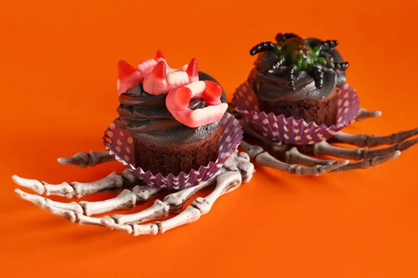 Mãos Esqueleto Com Deliciosos Cupcakes Halloween Fundo Vermelho Close — Fotografia de Stock