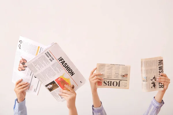 軽い背景に異なる新聞を持つ女性の手 — ストック写真