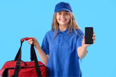 Mavi arka planda termal çantalı ve cep telefonlu kadın kurye