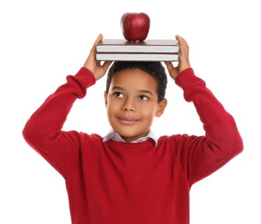 Beyaz arka planda kitapları ve elması olan küçük Afro-Amerikalı öğrenci.