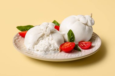 Sarı arka planda lezzetli Burrata peyniri tabağı.