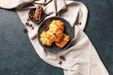 Siyah arka planda lezzetli balkabağı şekilli çörekler.