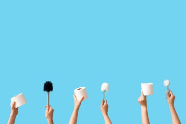 Tuvalet fırçaları ve mavi arka planda kağıt ruloları olan kadınlar.