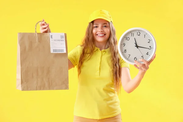 Correio Feminino Com Saco Papel Relógio Fundo Amarelo — Fotografia de Stock