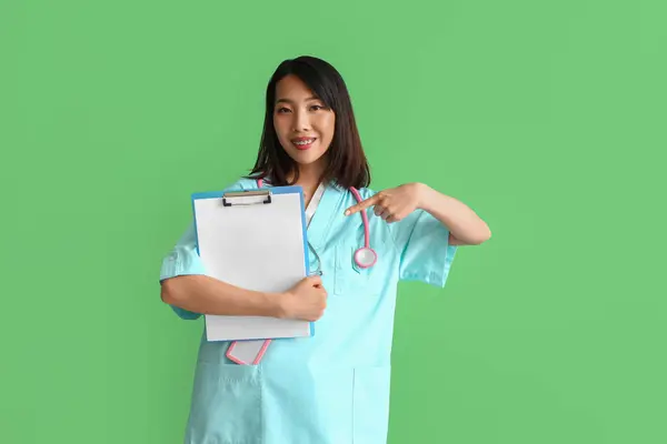 Vrouw Aziatische Medisch Stagiair Wijzend Klembord Groene Achtergrond — Stockfoto