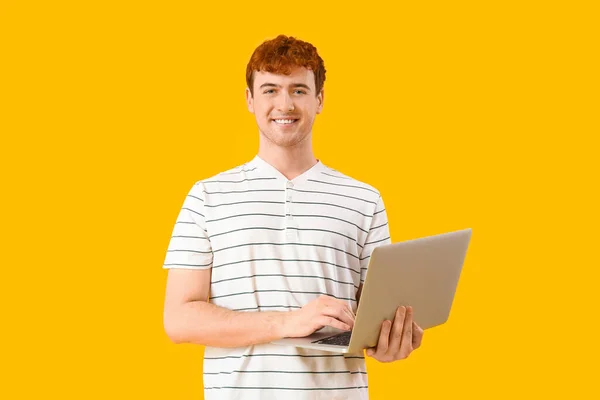 黄色の背景でラップトップで作業男性プログラマー — ストック写真