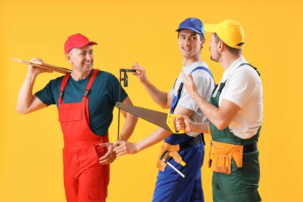 Team Van Mannelijke Bouwers Met Gereedschap Gele Achtergrond — Stockfoto