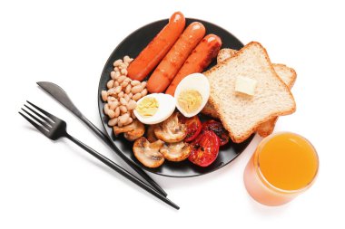 Lezzetli İngiliz kahvaltısı tabağı ve beyaz arka planda bir bardak meyve suyu.