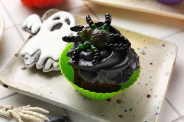 Tatlı bir Cadılar Bayramı keki ve açık fayanslı kurabiye tabağı.