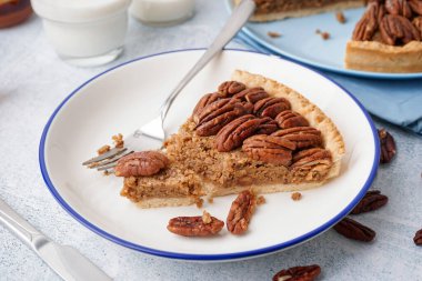 Gri arka planda bir parça lezzetli cevizli turta.