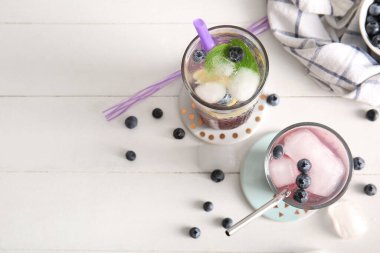 Beyaz ahşap masada naneli taze yabanmersinli limonata.