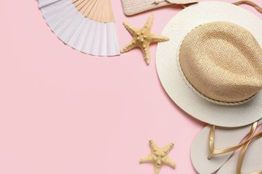 Plaj aksesuarları ve pembe arka planda deniz yıldızları olan kompozisyon