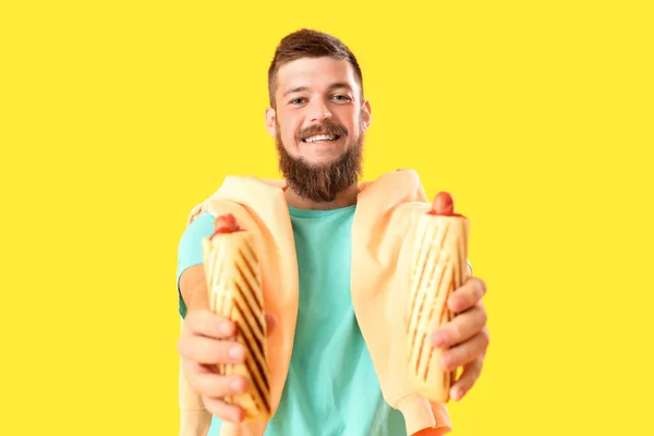 Portrét Šťastného Mladého Muže Chutnými Hot Dogy Žlutém Pozadí — Stock fotografie