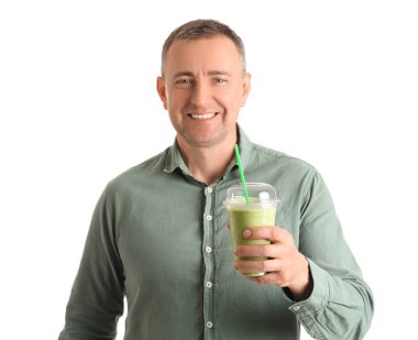 Beyaz arka planda bir bardak sebze suyu olan olgun bir adam.