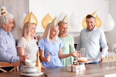 Olgun insanlar mutfakta doğum gününü kutluyor.