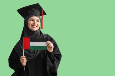 Yeşil arka planda BAE bayrağı taşıyan Müslüman lisans öğrencisi