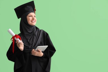 Yeşil arka planda diploma ve tablet bilgisayarı olan Müslüman lisans öğrencisi