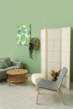 Oturma odası, koltuk, gri kanepe ve resim.