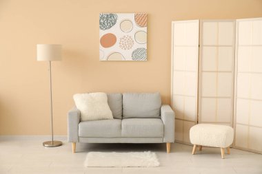 Gri kanepeli, katlanır perdeli ve boyalı bir oturma odası.